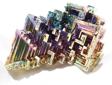 crystals of Bismuth form regular geometric shapes and refracted light gives them bright colors