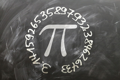 3.1415926535897932384626433 handwritten in a circular pattern around a large 'pi' symbol, all in chalk on a blackboard.